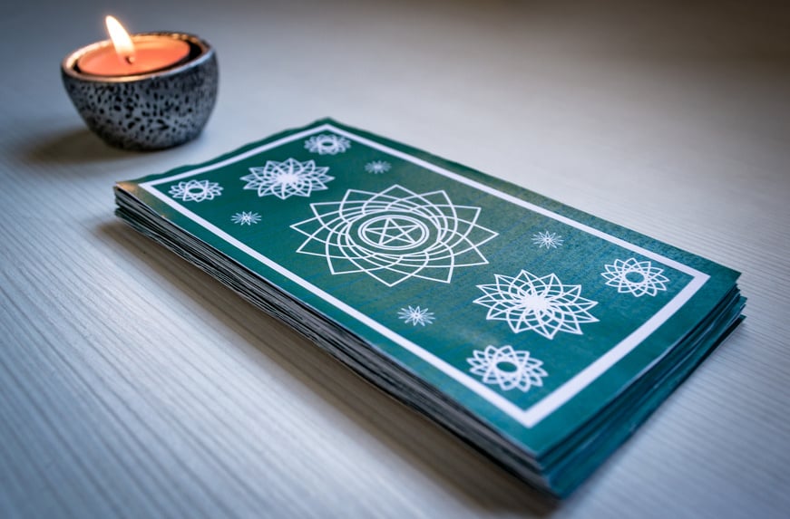 Stack  of Green Tarot Cards with Lighted Candle 